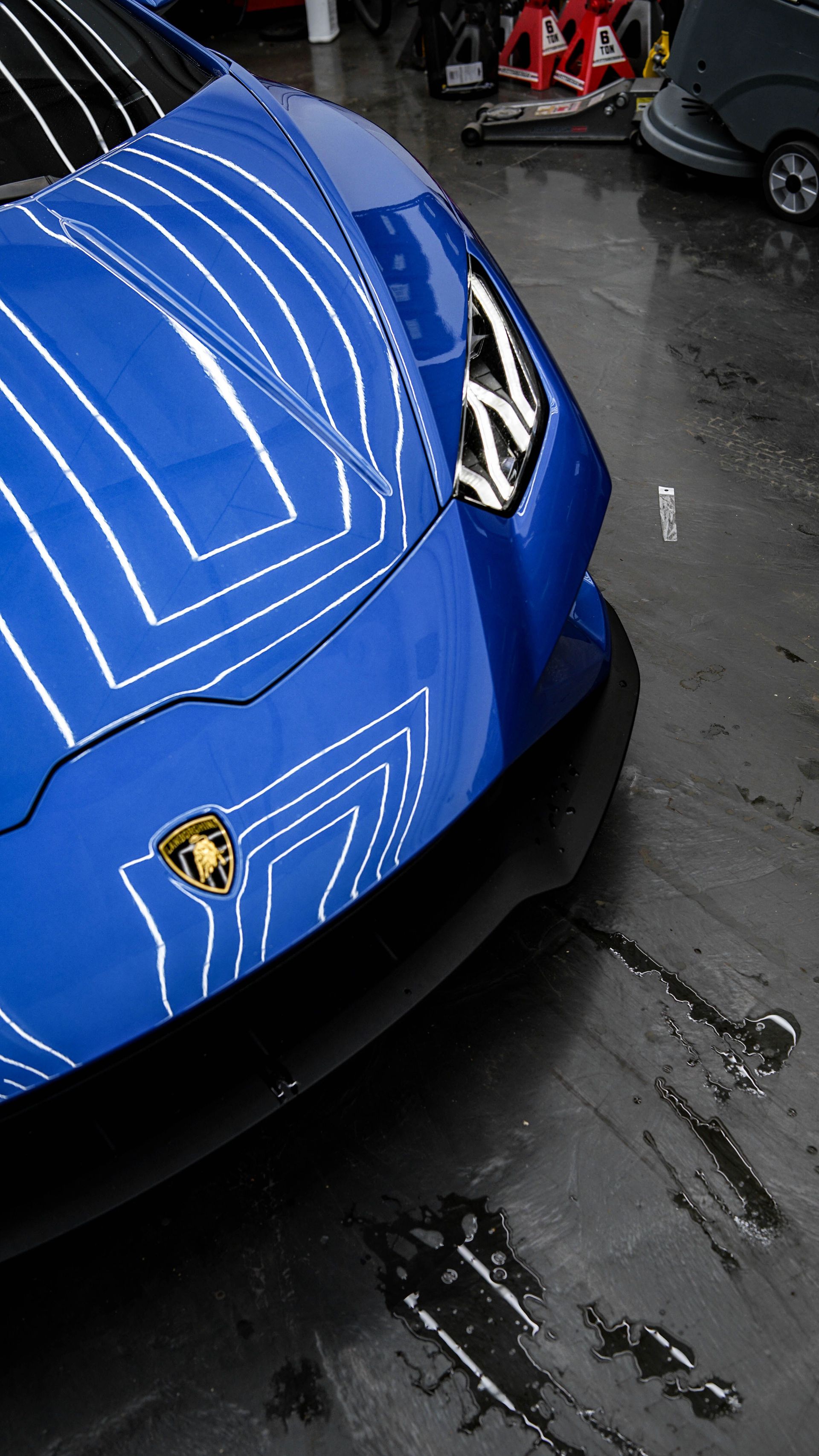A detailed shot of a blue Lamborghini Huracan showcasing its design and emblem.